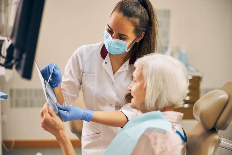 dentist showing an older woman her x-ray results in narre warren